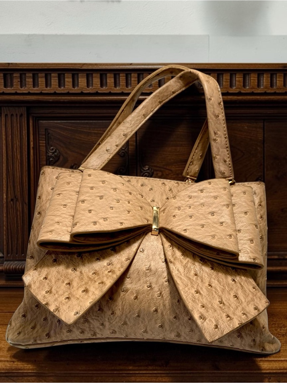 Crossi Woman’s Ostrich Faux Leather Bow Bag tote with a statement bow front.